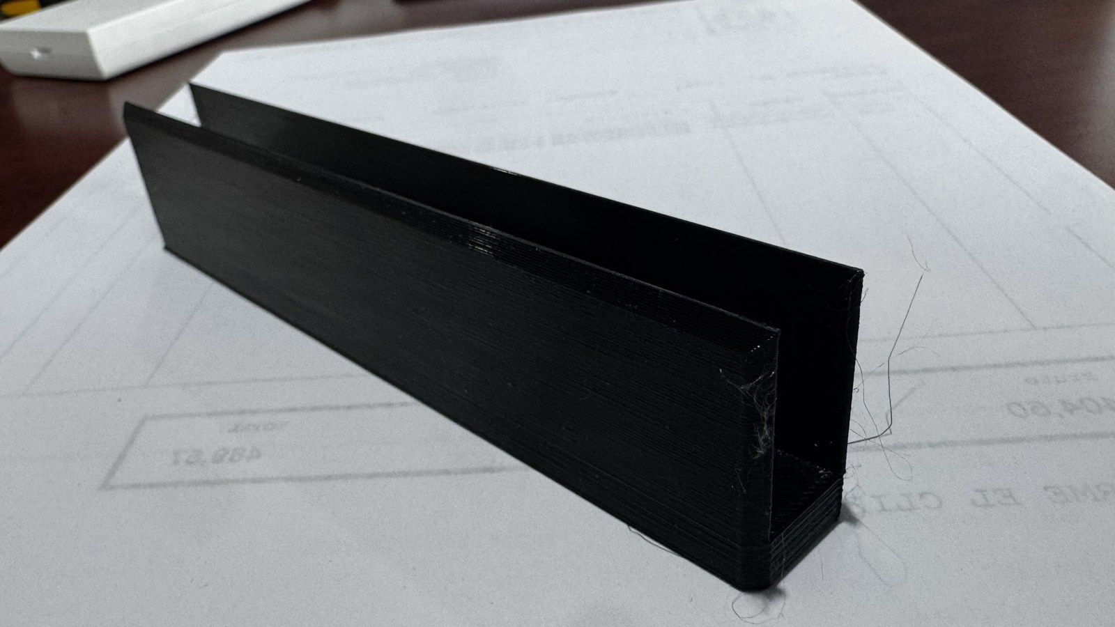 Pieza alargada negra fabricada mediante impresión 3D